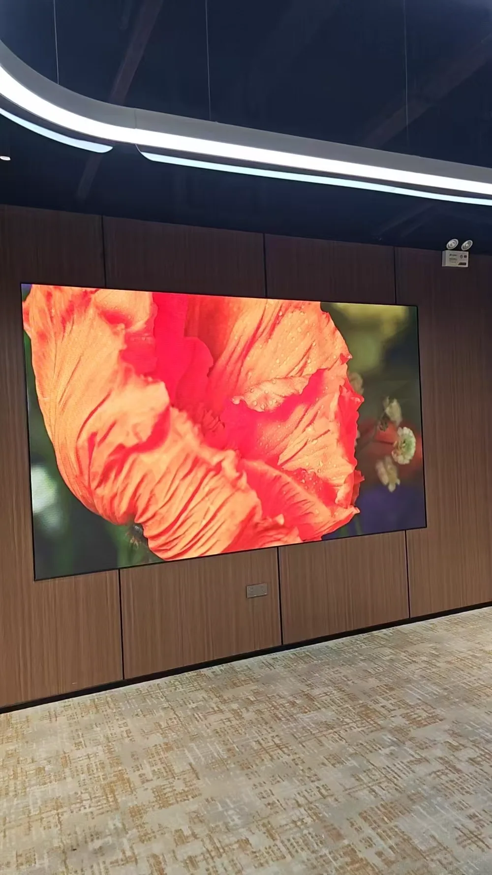Wall-mounted LED display integrated into a modern corporate meeting space