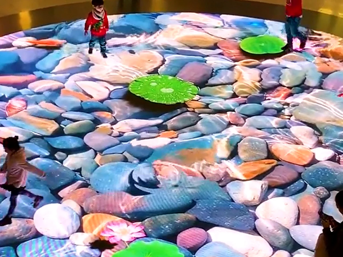 Children interacting with responsive stone and water content on an LED floor