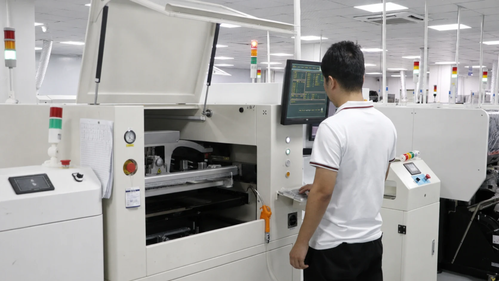 Technician monitoring LED module production equipment
