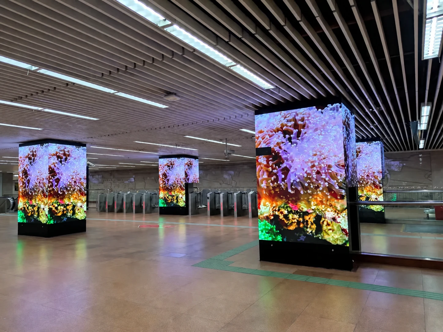 Custom LED display columns integrated into a metro station